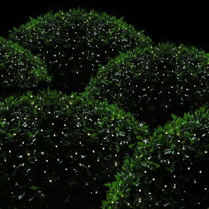 Маленькие светодиодные фонари в кустах напоминают светлячков